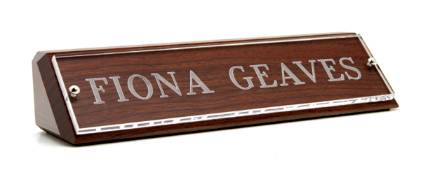 Engraved nameplates are made of Lucite mounted onto a block of solid wood.